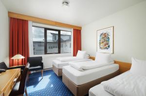 um quarto de hotel com duas camas e uma secretária e uma janela em Hotel Örk em Hveragerði