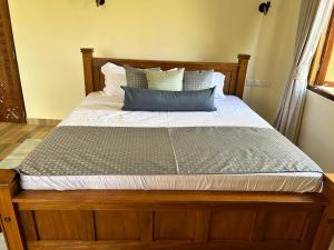 een bed met een houten frame en kussens erop bij Executive three bedroom, Furnished in Diani Beach