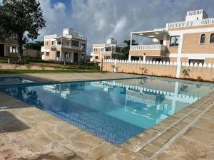 een groot zwembad voor een gebouw bij Executive three bedroom, Furnished in Diani Beach