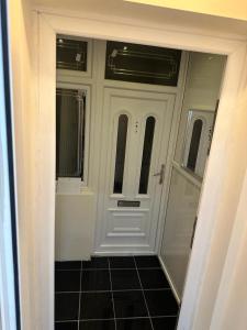 een witte deur in een kamer met een tegelvloer bij Elegant Square in Hither Green