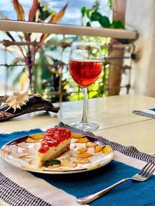 Marina 4Rooms في سان فيسنتي: طبق من الطعام وكأس من النبيذ على طاولة