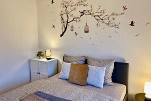 a bedroom with a bed and a tree with birds at Dejlig 2 værelses lejlighed in Randers