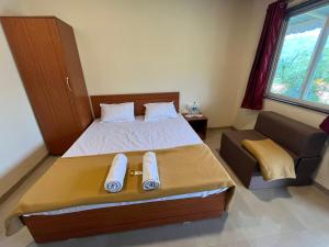 - une chambre avec un grand lit et un canapé dans l'établissement VRISA Mountain Retreat, à Pune