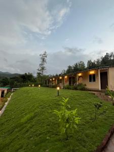 a yard with a house with lights on it at VRISA Mountain Retreat in Pune