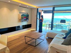 a woman standing in a living room looking out the window at Espectacular casa de diseño alto standing in Alella