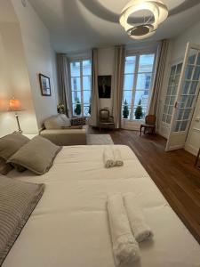 a large white bed in a room with windows at Aux Terrasses de la Lune in Paris