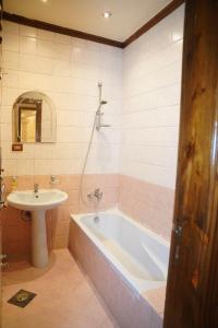 uma casa de banho com uma banheira e um lavatório em Tunis Beach Families Only em Fayum