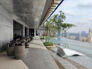 a building with a swimming pool with a view of a city at Axon Serviced Suites in Kuala Lumpur