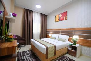 una camera d'albergo con letto e sedia di Emirates Stars Hotel Apartments Dubai a Dubai