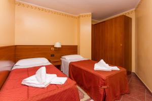 a hotel room with two beds with towels on them at Relais Des Alpes in Sauze dʼOulx