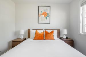a bedroom with a large white bed with orange pillows at Concord 3br w backyard patio nr Mt Diablo SFO-1579 in Concord