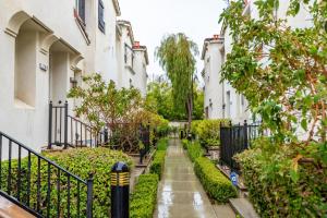 a walkway between two buildings with bushes and trees at Milpitas 2br w garage nr coffee groceries SFO-1597 in Milpitas
