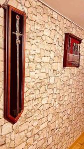 un mur en pierre avec une croix et deux fenêtres dans l'établissement La chambre des secrets Perougien, à Pérouges