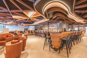 a bar in a restaurant with a bunch of stools at Hotel Laudinella in St. Moritz