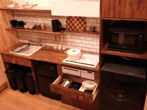uma pequena cozinha com um lavatório e um micro-ondas em 京都 三日月 Mikazuki em Quioto