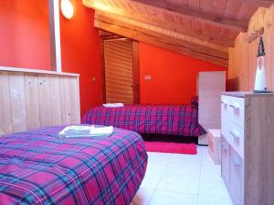 聖洛倫索巴納勒的住宿－Alloggio la Falesia，一间带两张床和红色墙壁的卧室