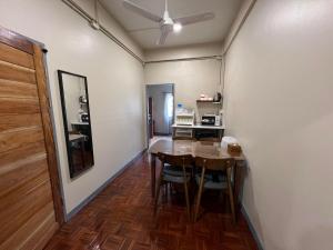 a dining room with a table and a kitchen at Achcha Family Hotel in Bangkok