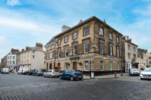 un bâtiment dans une rue avec des voitures garées devant elle dans l'établissement The Scott Apartment, à Kelso