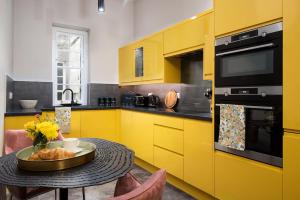 a kitchen with yellow cabinets and a table with a plate of food at The Scott Apartment in Kelso