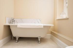 a white bath tub in a bathroom with a sink at The Scott Apartment in Kelso