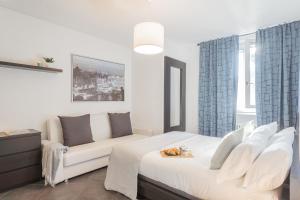 a white bedroom with a bed and a couch at Chiara's Apartment by Rent All Como in Como