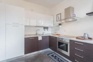 a kitchen with white and brown cabinets and a sink at Chiara's Apartment by Rent All Como in Como +41 photos