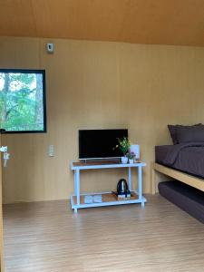a room with a bed and a television on a table at Great Panorama Lodge and Camping in Lembang
