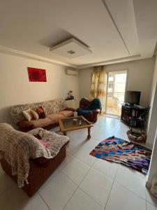 ein Wohnzimmer mit einem Sofa und einem Tisch in der Unterkunft AGORAMI in Nabeul