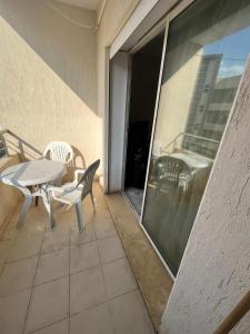 eine Terrasse mit einem Tisch und Stühlen auf dem Balkon in der Unterkunft AGORAMI in Nabeul