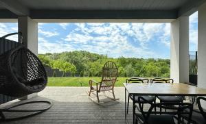 eine Terrasse mit einem Tisch, Stühlen und einer Schaukel in der Unterkunft Студія Terrasa in Czernowitz