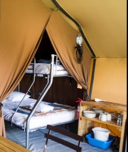 Saint-Benoît-sur-LoireにあるCAMPING ONLYCAMP LE PORTのテント内の二段ベッド2台が備わる客室です。