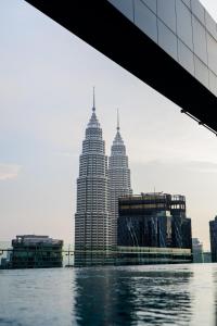クアラルンプールにあるRoyce KLCC Kuala Lumpur City Centre by Dormeo Destinationsのペトロナスのツインタワーを望む水辺の景色を望めます。