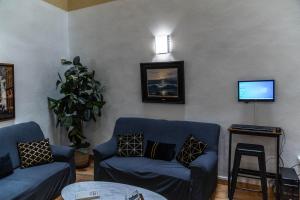 فندق جرانادا سنترو في غرناطة: غرفة معيشة مع اثنين من الأرائك الزرقاء وتلفزيون
