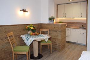 a kitchen with a table with a bowl of fruit on it at Gmeinder's Landhaus in Immenstadt im Allgäu