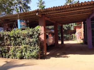 a bus parked under a building with a roof at Sai Sadan Residency,Diveagar in Diveagar