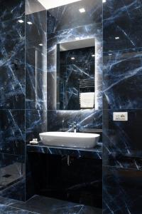 a black bathroom with a sink and a mirror at Relais del Portico in Rome +45 photos