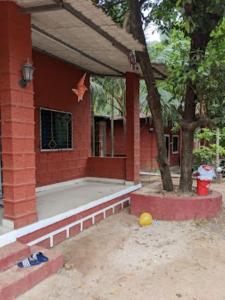 a red brick house with a tree in front of it at Sai Sadan Residency,Diveagar in Diveagar