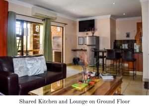 a living room with a couch and a table at Eldorado Lodge CC in Kuruman