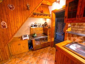 una pequeña cocina con armarios de madera y fregadero en willa Partykówka, en Poręba Wielka