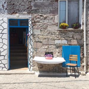 une chaise et un lavabo en face du bâtiment dans l'établissement Portakal Çiçeği, à Sefaçamlık