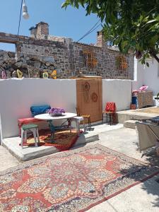 d'une terrasse avec une table, des chaises et un tapis. dans l'établissement Portakal Çiçeği, à Sefaçamlık