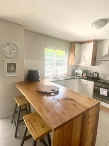 a kitchen with a wooden table and a clock on the wall at Devine Stay in Paarl