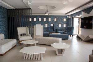 a living room with a couch and chairs and tables at Impecto Guest House in Jozini