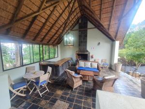 an outdoor living room with a fireplace and a table and chairs at 60 on Monica, 6 Bedroom Lesedi Lodge, Hartbeespoort in Hartbeespoort
