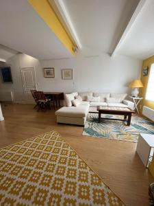 a living room with a white couch and a table at Appartement avec deux terrasses traversantes au cœur d'une ancienne Abbaye in Montélimar