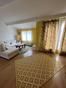 a living room with a couch and a rug at Appartement avec deux terrasses traversantes au cœur d'une ancienne Abbaye in Montélimar