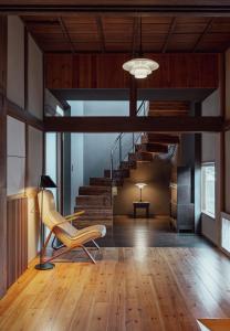 een woonkamer met een stoel en een trap bij 葉山 - Nowhere but Hayama in Hayama