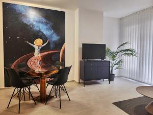 B130 "Cosmic Harbor" Apartment في بودابست: غرفة بطاولة عليها لوحة لفتاة على الكون
