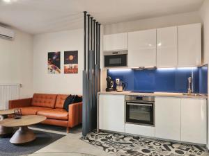 B130 "Cosmic Harbor" Apartment في بودابست: مطبخ مع أريكة وطاولة في الغرفة