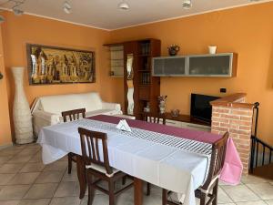 a dining room with a table and a tv at ML HOUSE VIVALDI in Podenzano